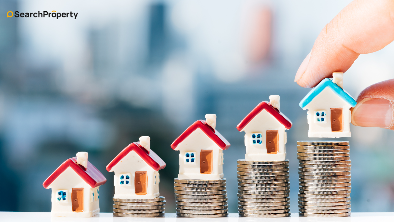 Stacked coins with house models showing property investment growth