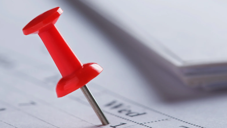 Red push pin on a calendar