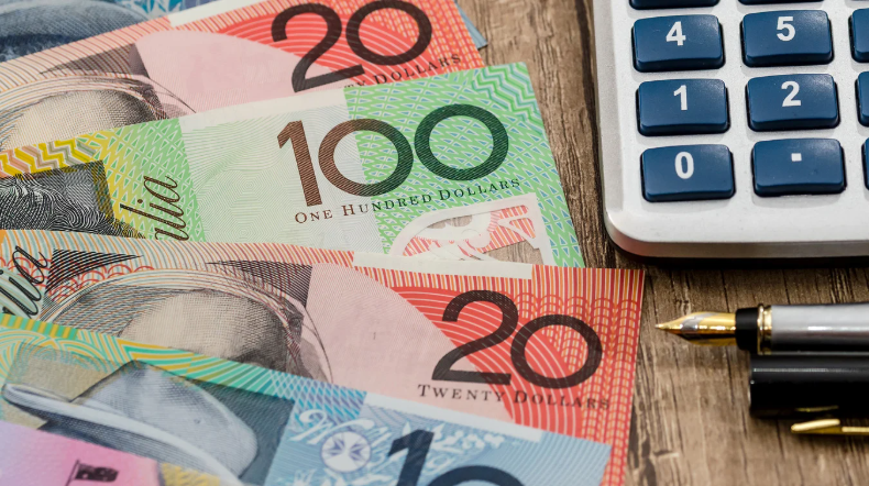 Australian banknotes, accompanied by a calculator and a fountain pen.