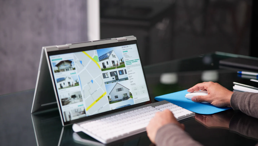 : Person browsing real estate listings on a convertible laptop