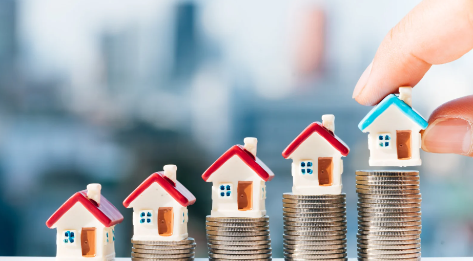 A miniature house on top of stacked coins, symbolising rising real estate prices