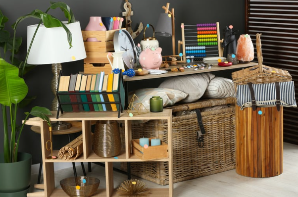 Assorted household and decorative items arranged on wooden and wicker furniture.