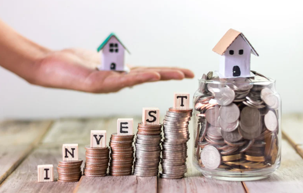 Stacked coins spelling "INVEST," a jar of coins with a house on top, and a hand holding another house