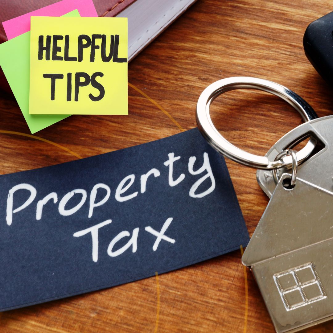 A 'Property Tax' sign with a keychain in the foreground, accompanied by a sticky note reading "HELPFUL TIPS." on a wooden surface.