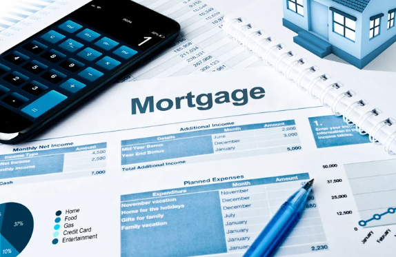 Mortgage budget sheet with financial planning tools including calculator, pen, notebook, and miniature house model—representing real estate investment budgeting and expense tracking.