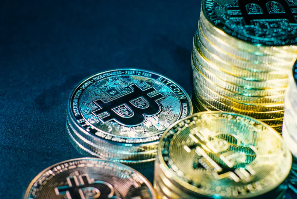 Close-up view of shiny physical Bitcoin coins stacked together, representing digital asset investments and alternative financing for real estate.