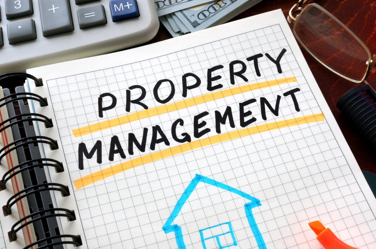 Notebook with handwritten 'Property Management' title and house sketch, representing real estate administration and landlord services.