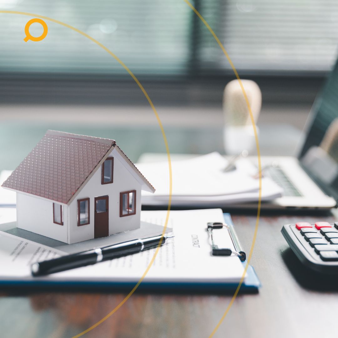 Miniature house on a table, with laptop and stamp, symbolising property investment journey