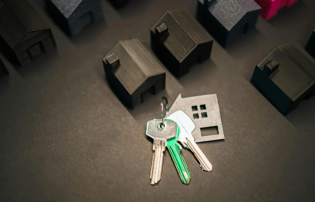 Miniature black houses and keys, symbolising property investment.