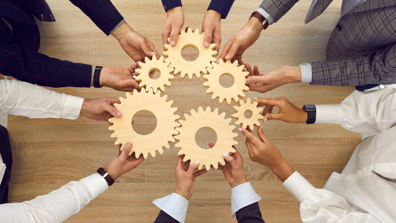 A group of people holding wooden gears together.