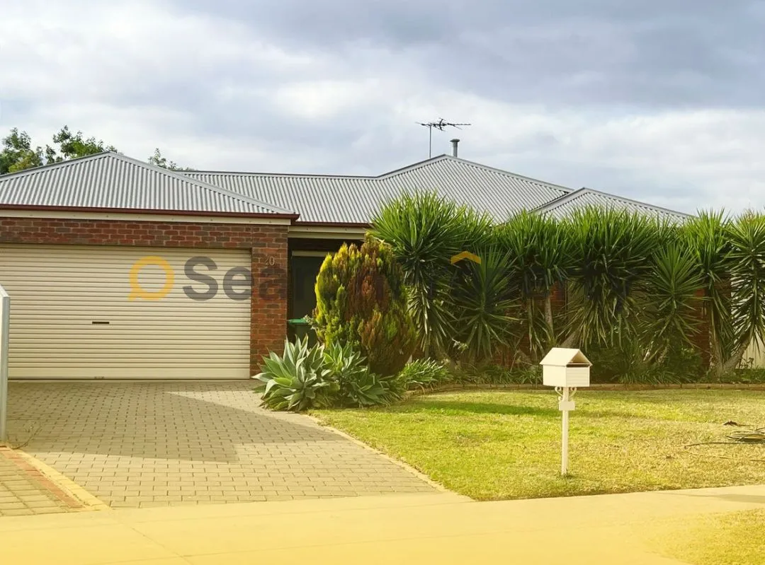 Exterior of a suburban Australian home with metal roofing, roller garage door, and tropical landscaping—ideal for illustrating residential investment property in a quiet neighbourhood.