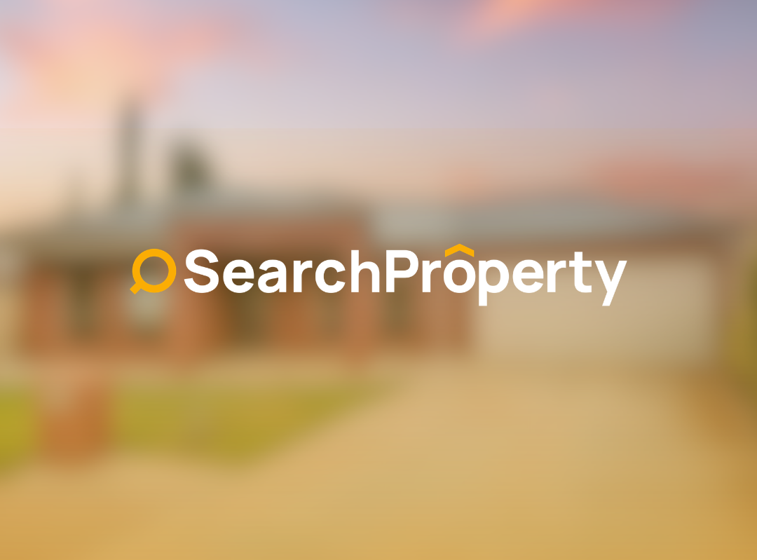 Single-storey brick home with a double garage, neat front lawn, and wide driveway under a pastel sunset sky.