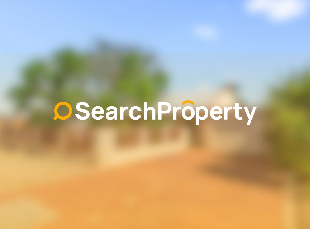 Charming single-storey investment property with a brick façade, pitched roof, mature trees, landscaped front garden, and a spacious driveway under a clear blue sky